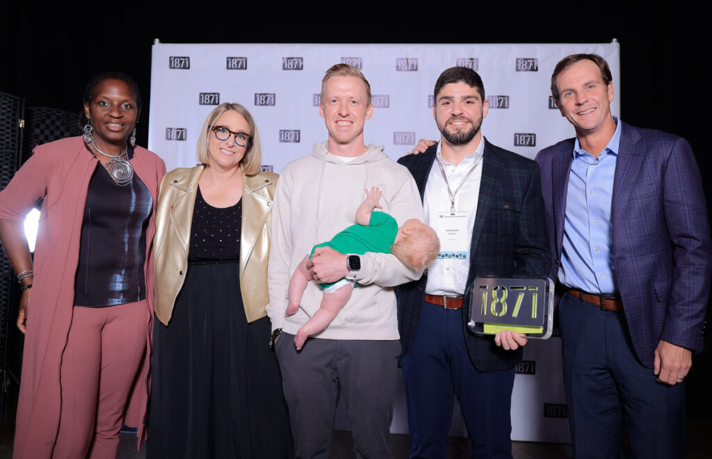 Hallow CEO Alex Jones (middle) and CFO Alessandro DiSanto (second from right) pose with 1871 CEO Betsy Ziegler (second from left) after winning the 2024 Momentum Award.